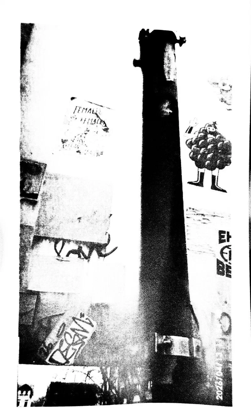 A pole covered in stickers and posters.