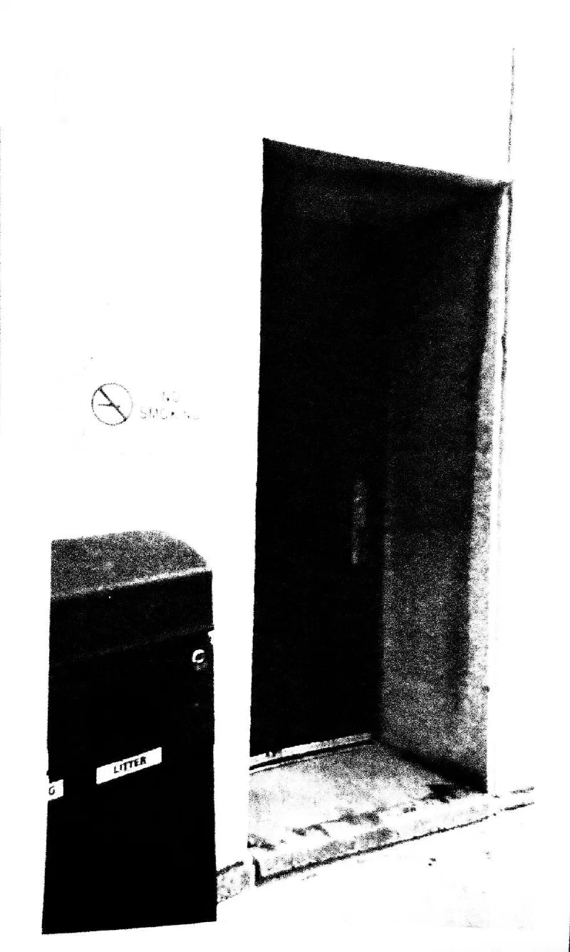 A dark doorway beside a litter bin.