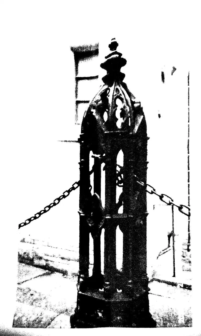 A cast-iron post with Gothic tracery, hung with chains.