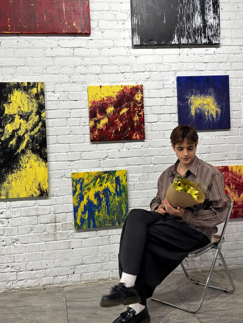Andrada with flowers in front of his wall at RCHIVE, on the night of the Art Gallery show, 4 June 2026.