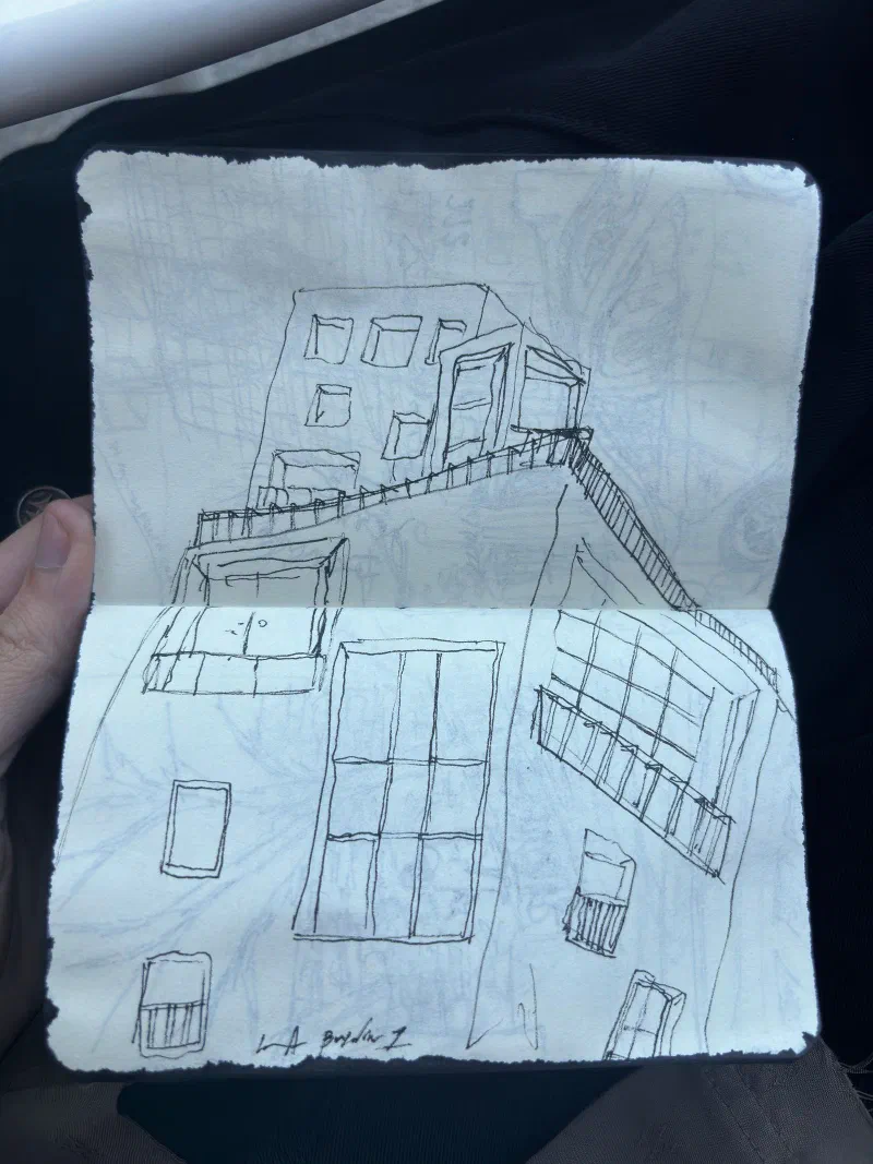 A pen drawing of a building's windows and terrace in a pocket sketchbook, July 2026.