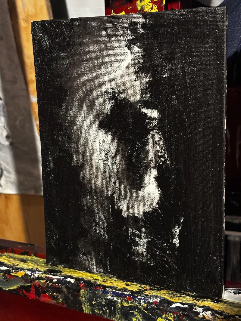 A face emerging from a black ground on a small canvas, July 2026.