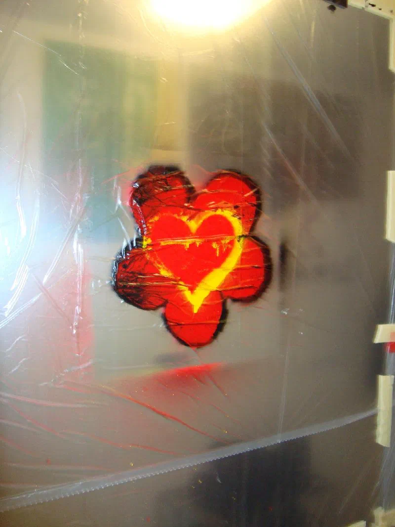 The first test of Andrada's heart-flower stencil, sprayed on the mirrored door of his first studio, 2024.